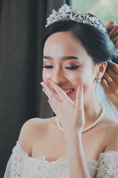 Smile of a woman wearing a white strapless lace wedding dress
